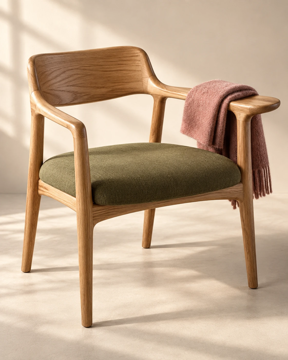 A wooden chair with olive upholstery and rose-colored cloth.